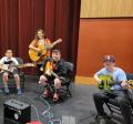 Children playing guitar with their instructor