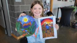 Child holding two paintings